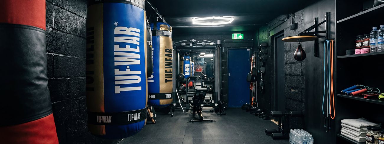Blue and gold TUF-WEAR heavy bags hanging along the MPL Box Fit training corridor